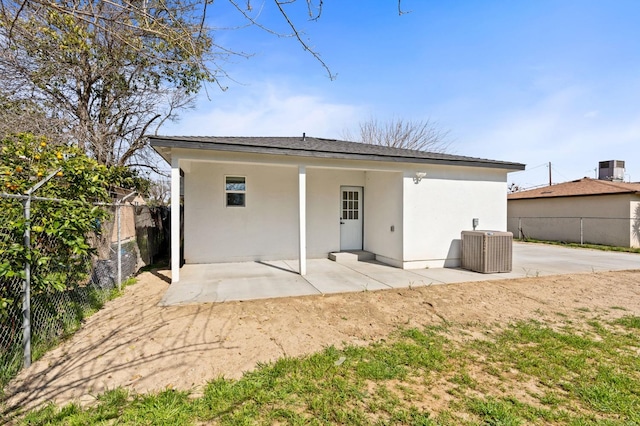 back of house featuring a patio, central AC unit, fence, and stucco siding