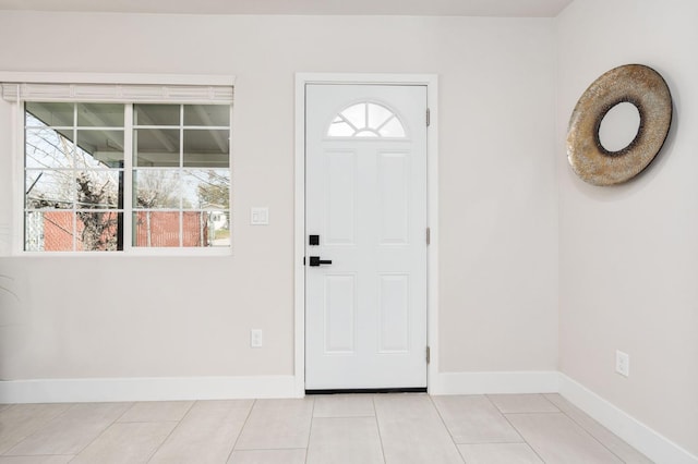 entryway with baseboards and light tile patterned flooring