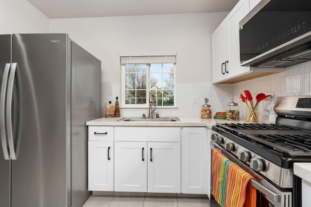 kitchen featuring decorative backsplash, stainless steel appliances, a sink, and light countertops