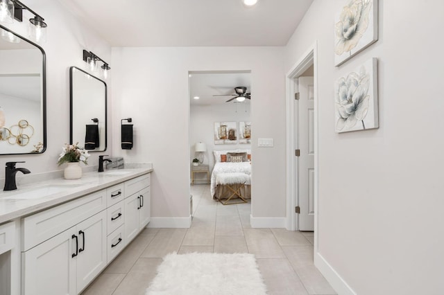 bathroom with double vanity, ensuite bathroom, a sink, and tile patterned floors