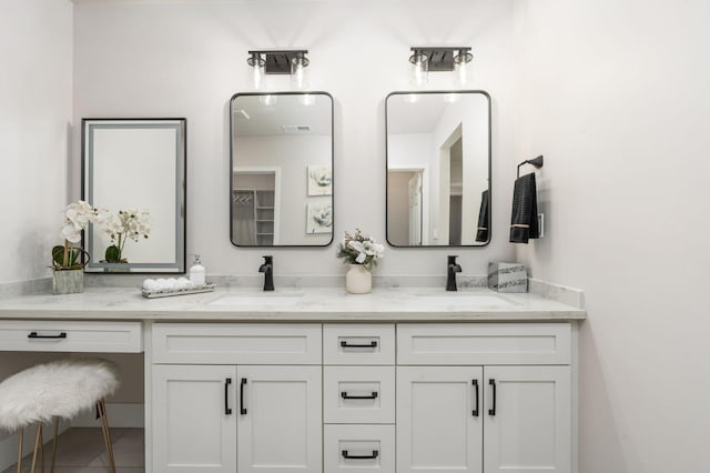 bathroom featuring double vanity, visible vents, and a sink