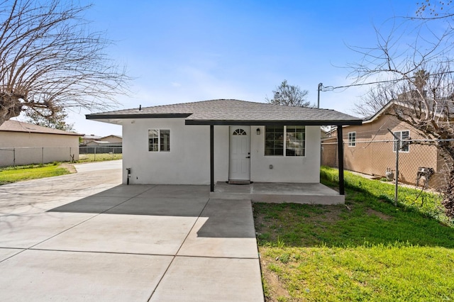 bungalow-style house featuring roof with shingles, a patio area, fence, and stucco siding