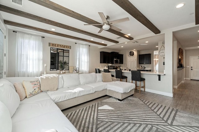 living room featuring recessed lighting, visible vents, wood finished floors, beamed ceiling, and baseboards