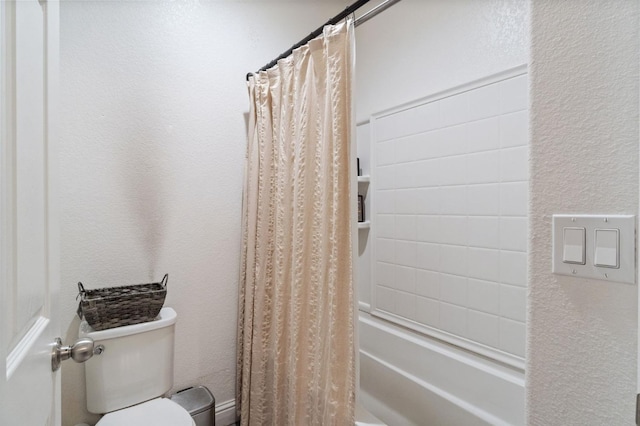 bathroom with toilet, shower / bathtub combination with curtain, and a textured wall