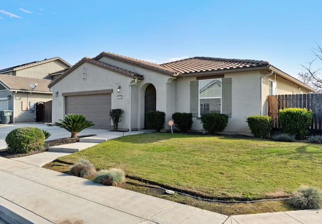 mediterranean / spanish-style home featuring an attached garage, fence, a tile roof, stucco siding, and a front yard