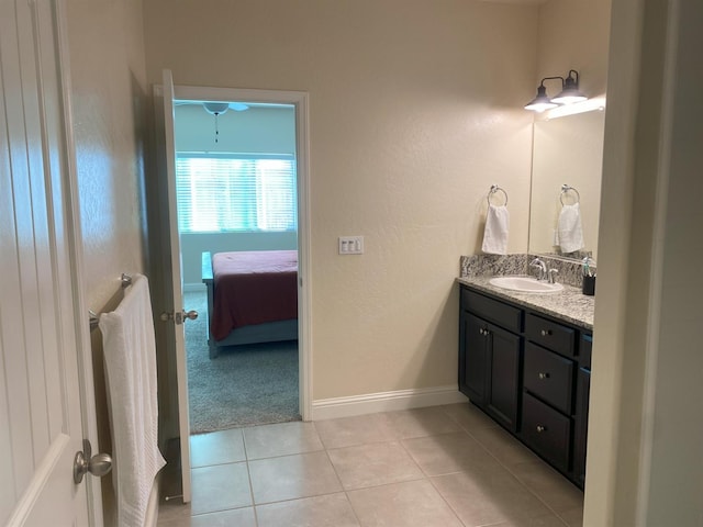 bathroom featuring ensuite bathroom, tile patterned flooring, vanity, and baseboards