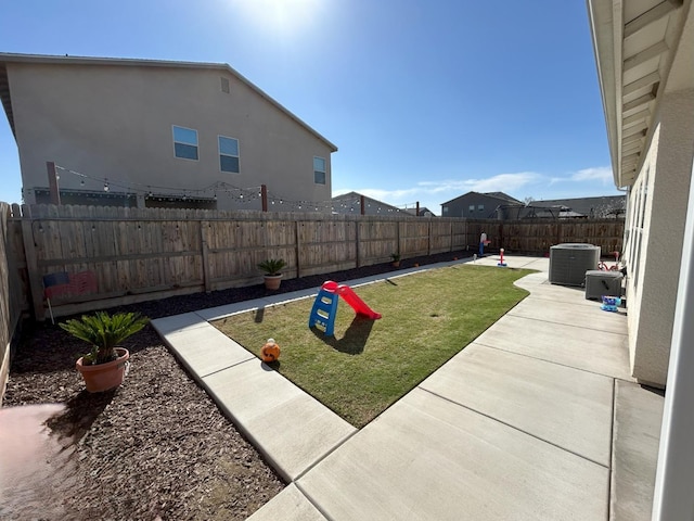 view of yard featuring a fenced backyard, central AC, and a patio