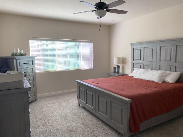 bedroom featuring baseboards, a ceiling fan, and light colored carpet