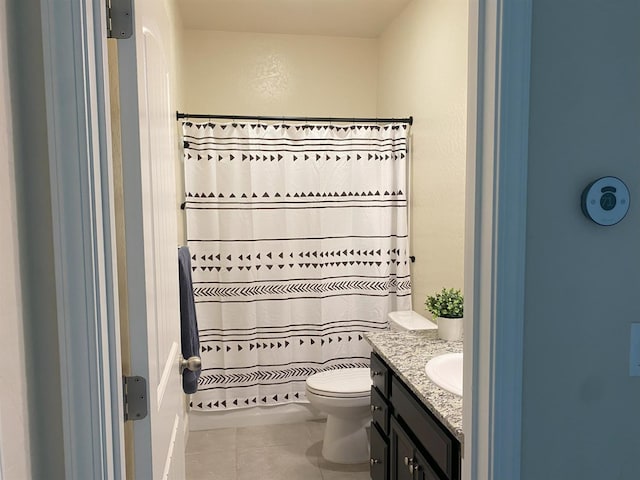 full bathroom featuring toilet, vanity, and tile patterned floors