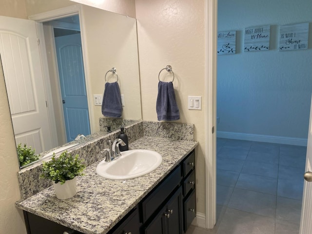 bathroom with baseboards, vanity, and tile patterned floors