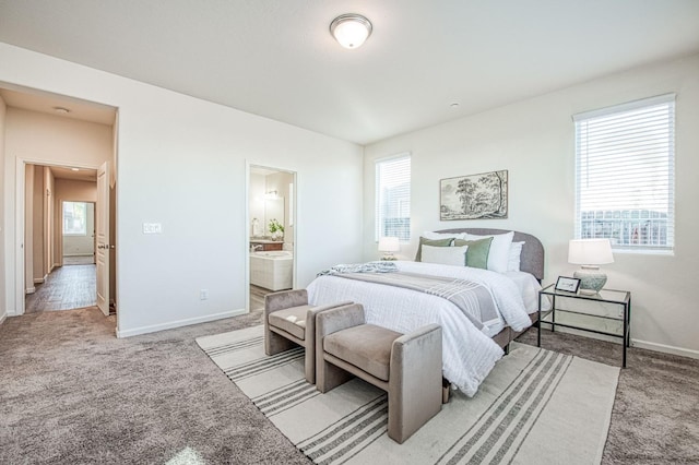 carpeted bedroom featuring baseboards and ensuite bathroom