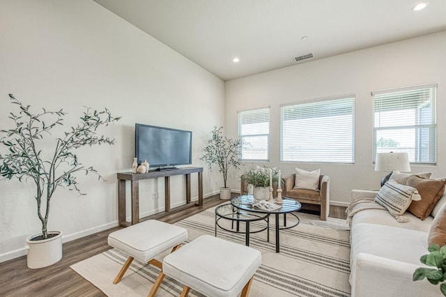 living room featuring a wealth of natural light, wood finished floors, visible vents, and baseboards