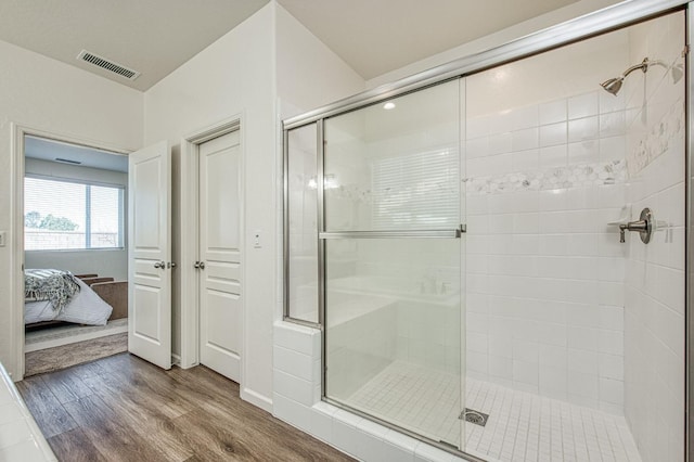 bathroom with wood finished floors, a stall shower, ensuite bath, and visible vents