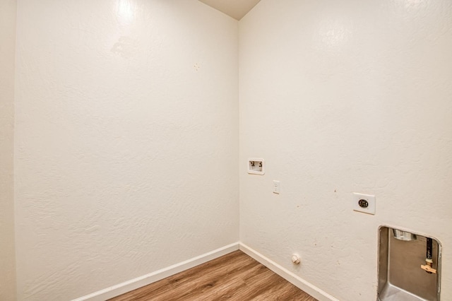 clothes washing area featuring washer hookup, light wood-style floors, hookup for an electric dryer, laundry area, and baseboards