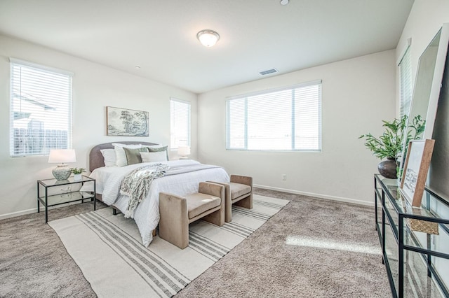 carpeted bedroom featuring baseboards and visible vents