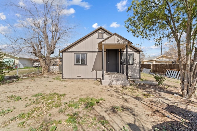 back of property with crawl space and fence