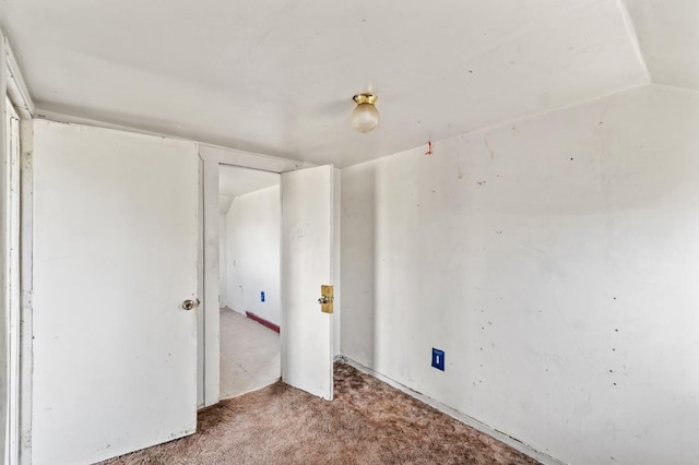 carpeted empty room with lofted ceiling