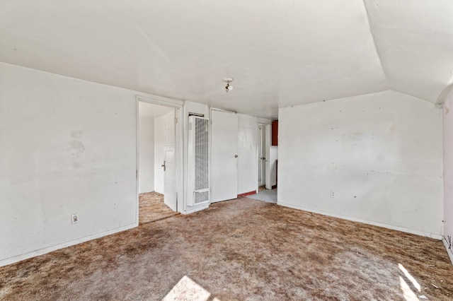 unfurnished bedroom featuring carpet floors and vaulted ceiling