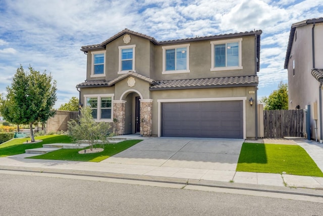 mediterranean / spanish-style home with fence, a tiled roof, an attached garage, and stucco siding