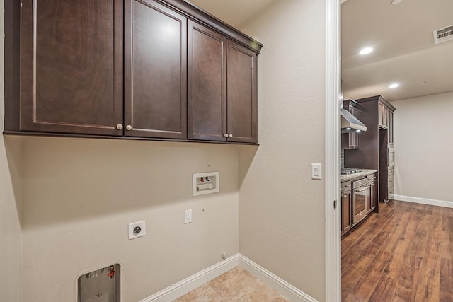 clothes washing area with baseboards, washer hookup, cabinet space, and hookup for an electric dryer