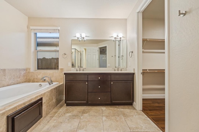 full bath featuring a spacious closet, a sink, and a bath