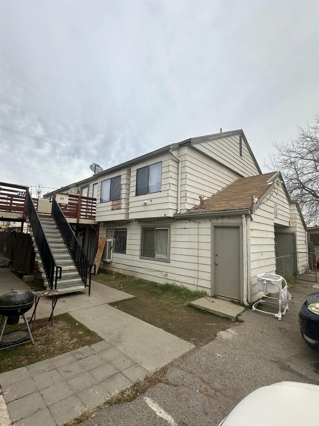 back of property featuring a garage and stairs