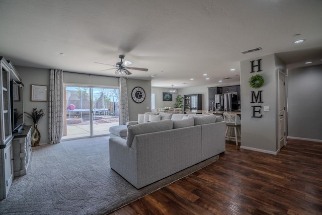 living room featuring baseboards, visible vents, a ceiling fan, dark wood-type flooring, and recessed lighting