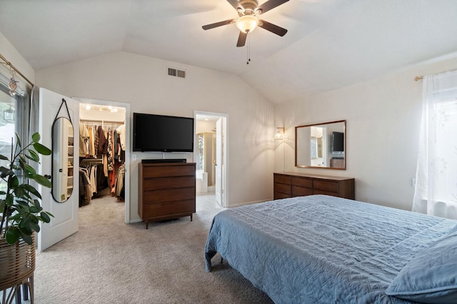 bedroom featuring carpet floors, a walk in closet, visible vents, and vaulted ceiling