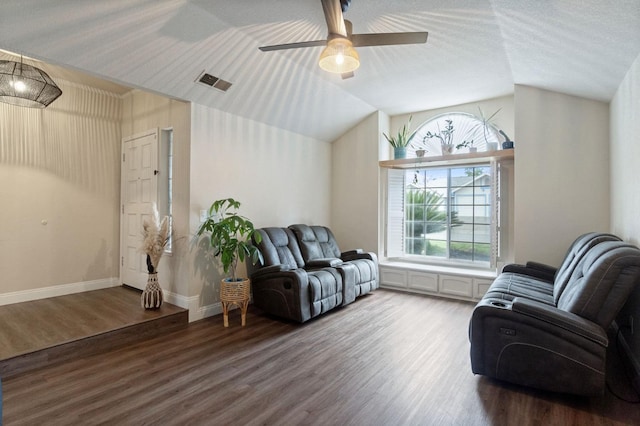 sitting room with visible vents, vaulted ceiling, and wood finished floors