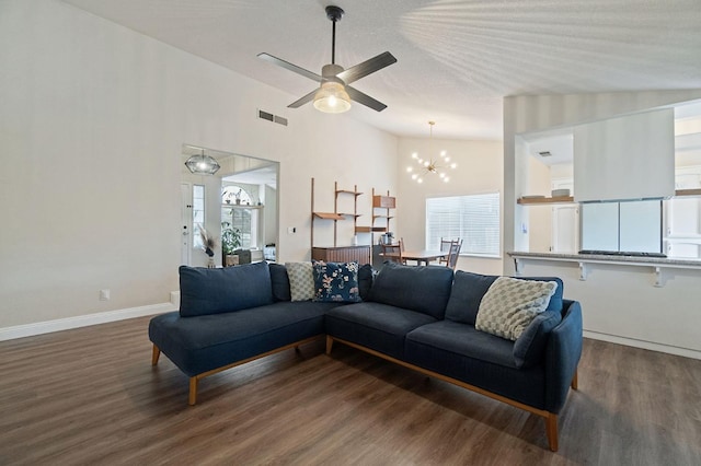 living area with lofted ceiling, visible vents, baseboards, and wood finished floors