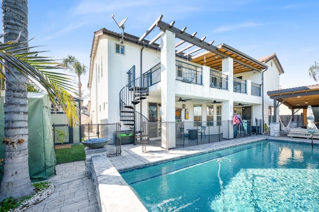 rear view of property with stucco siding, stairway, a patio area, ceiling fan, and fence