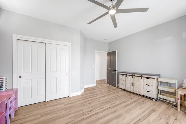 bedroom featuring light wood finished floors, a closet, a ceiling fan, and baseboards