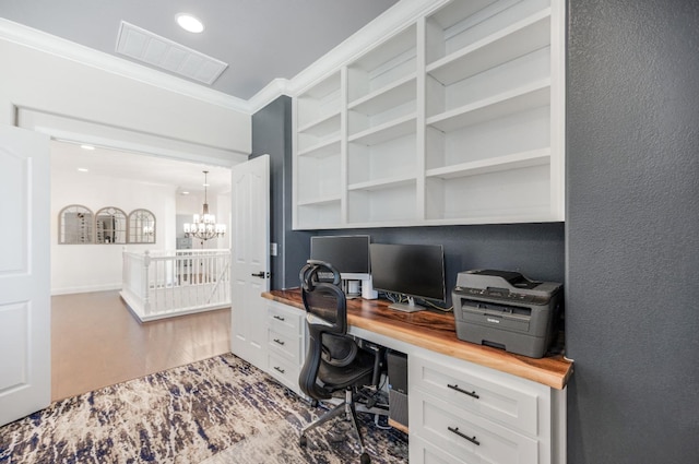 office with visible vents, a textured wall, ornamental molding, wood finished floors, and a chandelier