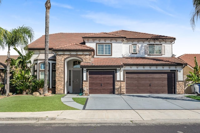 mediterranean / spanish-style house featuring stone siding, a tile roof, and stucco siding