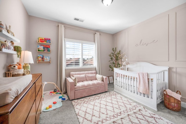 carpeted bedroom featuring a crib, baseboards, and visible vents