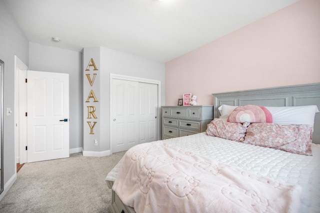 bedroom with baseboards, a closet, and light colored carpet