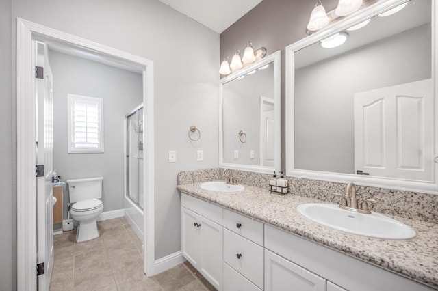 full bathroom with tile patterned flooring, a sink, toilet, and double vanity