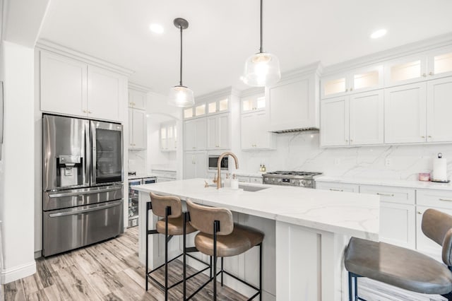 kitchen with stainless steel refrigerator with ice dispenser, decorative backsplash, stove, white cabinetry, and premium range hood