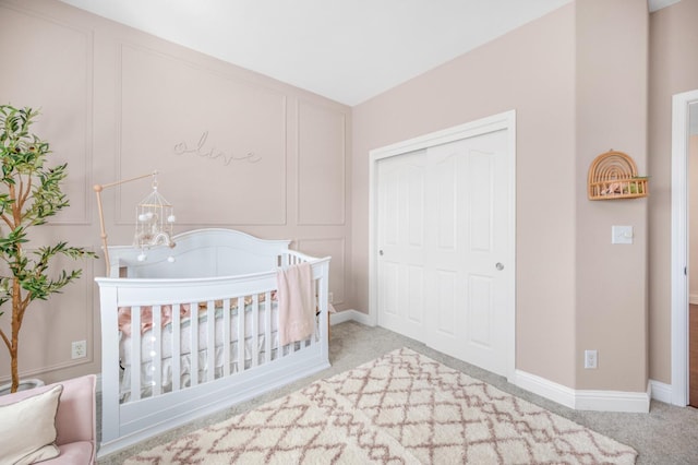 unfurnished bedroom with a decorative wall, baseboards, a closet, carpet, and an inviting chandelier