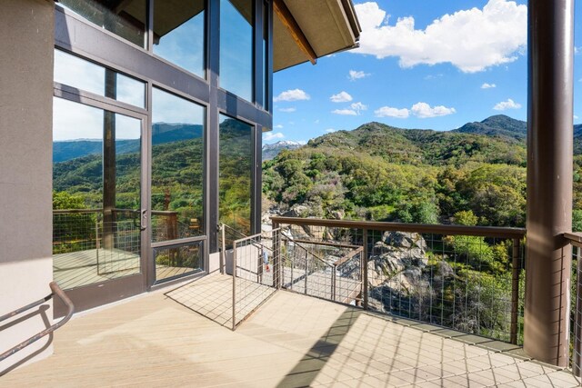 balcony featuring a mountain view and a wooded view