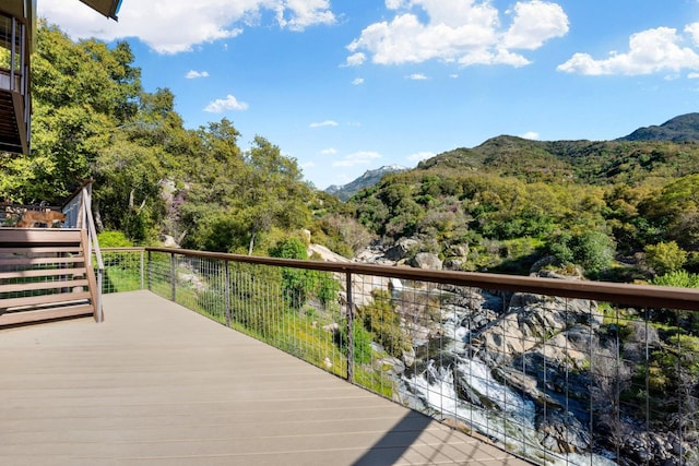 wooden terrace with a forest view and a mountain view