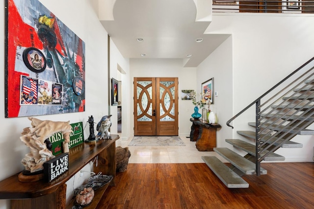 foyer entrance with stairs, wood finished floors, and recessed lighting