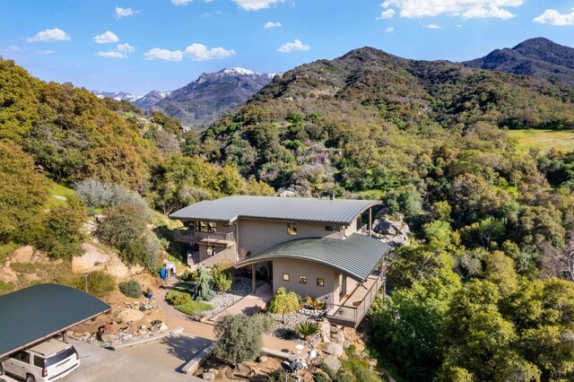 drone / aerial view featuring a mountain view and a view of trees