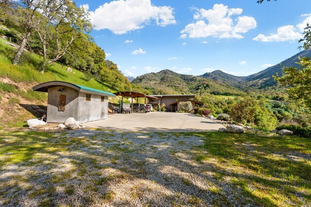 view of yard with a carport, driveway, and a mountain view