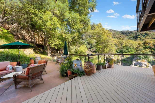 wooden deck featuring an outdoor living space and a forest view