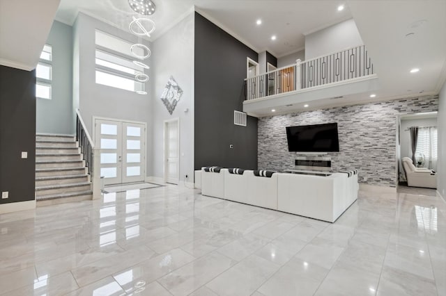 unfurnished living room with baseboards, stairs, marble finish floor, french doors, and ornamental molding