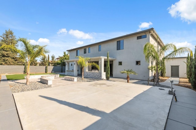 back of property with a patio area, fence, and stucco siding