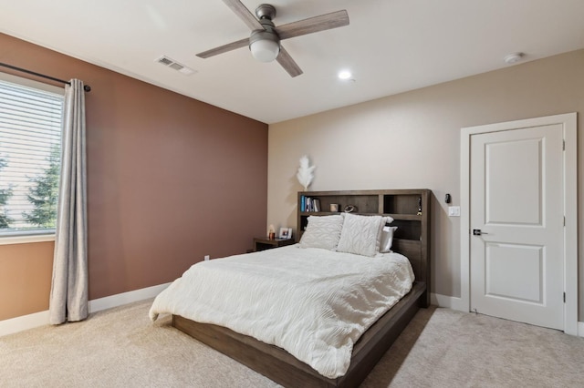 carpeted bedroom with baseboards, visible vents, and a ceiling fan