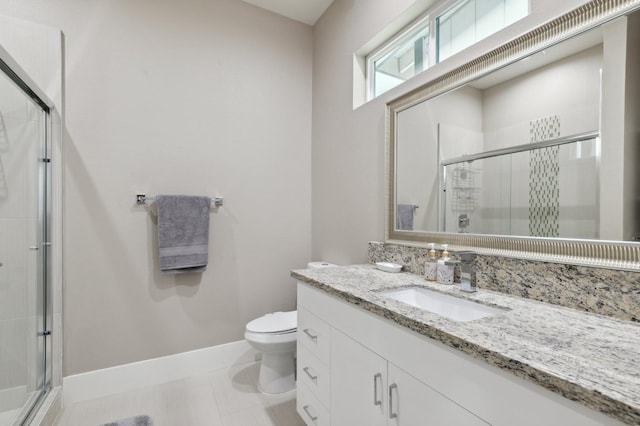 full bathroom featuring a stall shower, baseboards, toilet, tile patterned flooring, and vanity