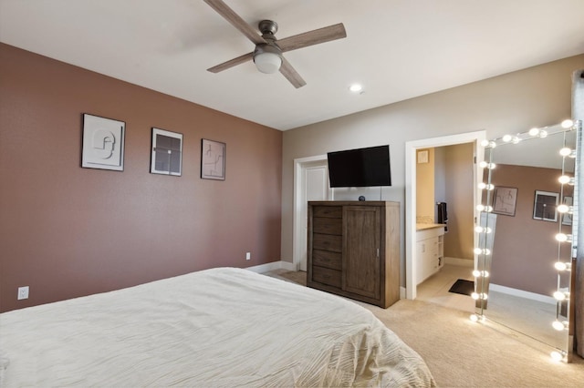 bedroom with ceiling fan, baseboards, connected bathroom, and light colored carpet